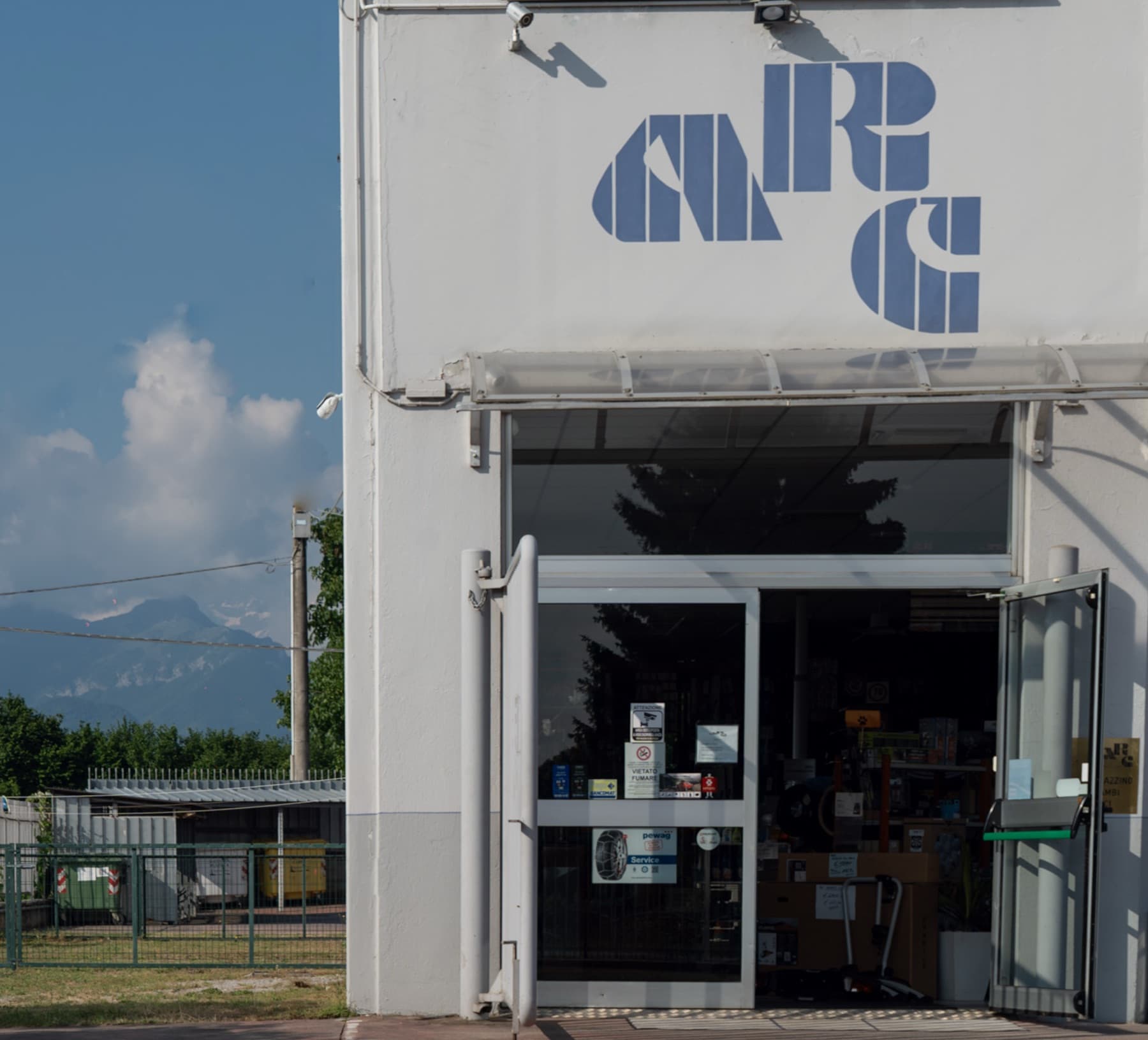 La facciata di ARC a Cuneo con il logo dipinto e le Alpi sullo sfondo